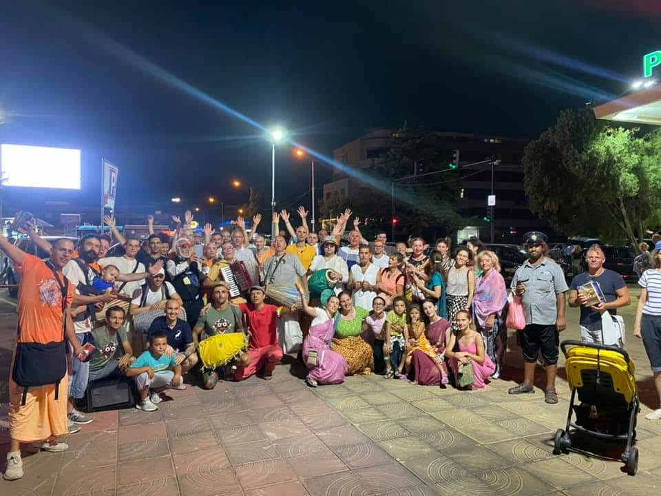 Harināma-saṅkīrtan in the city — devotees gathered under the evening lights