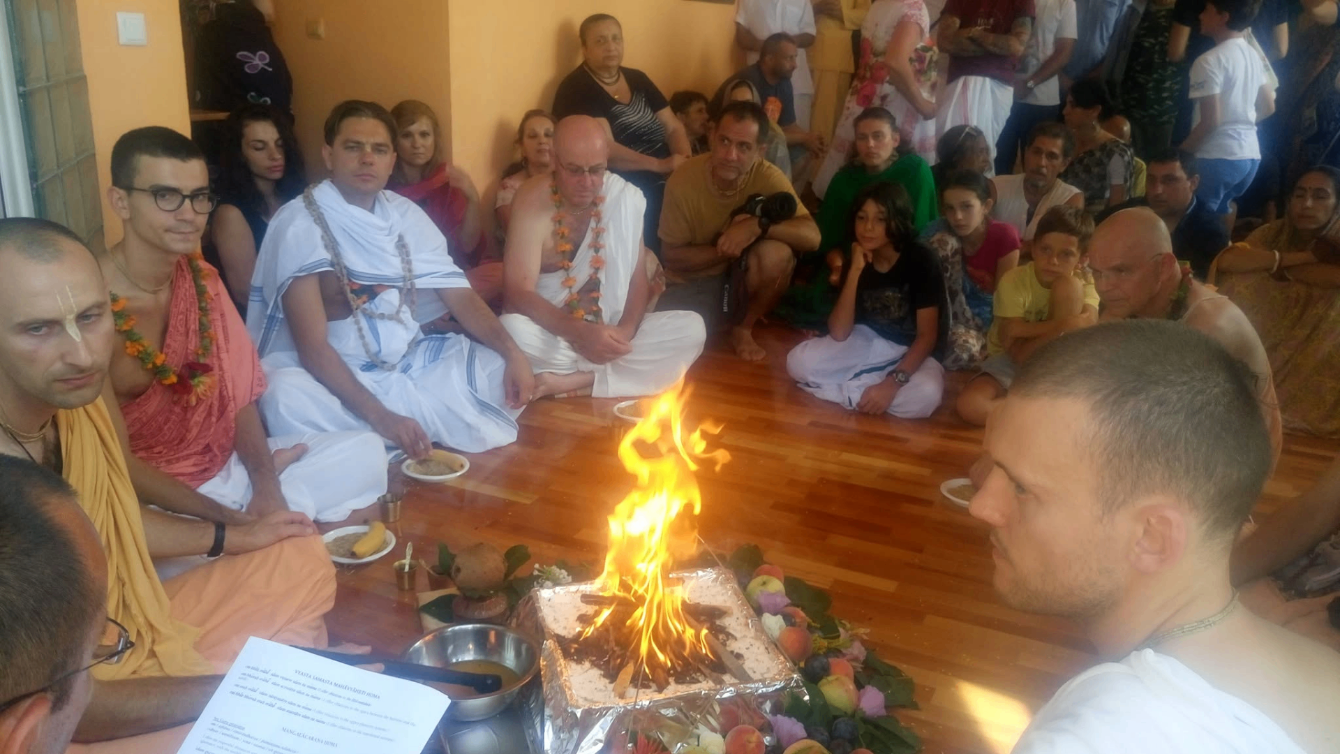 Fire yajña with the community — devotees gathered around the sacred flames