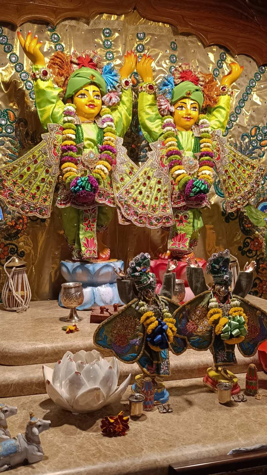 Śrī Śrī Gaura-Nitāi on the altar in festive green vestments, with offerings before Them