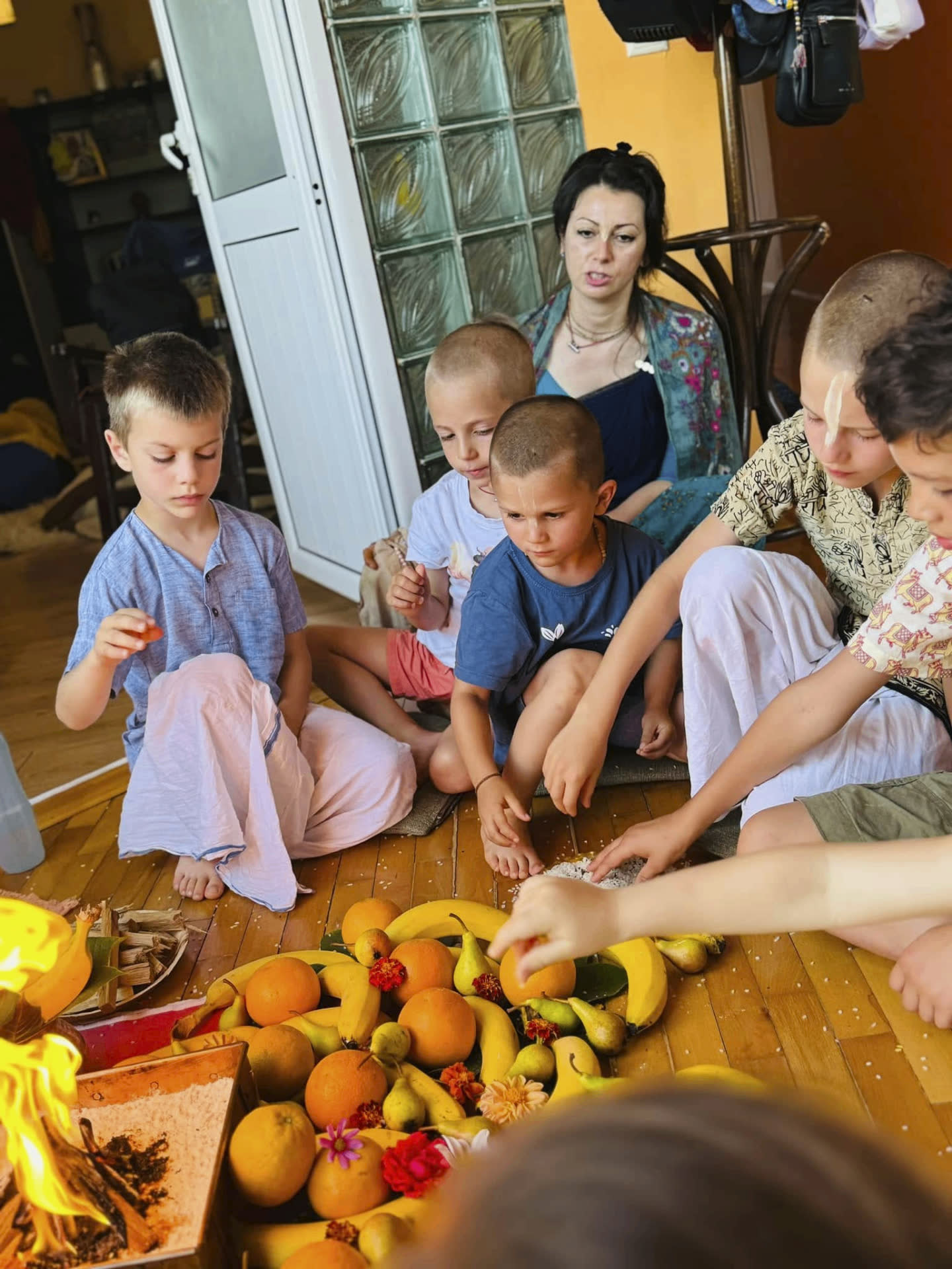 Children offering fruits and grains into the sacred fire yajña