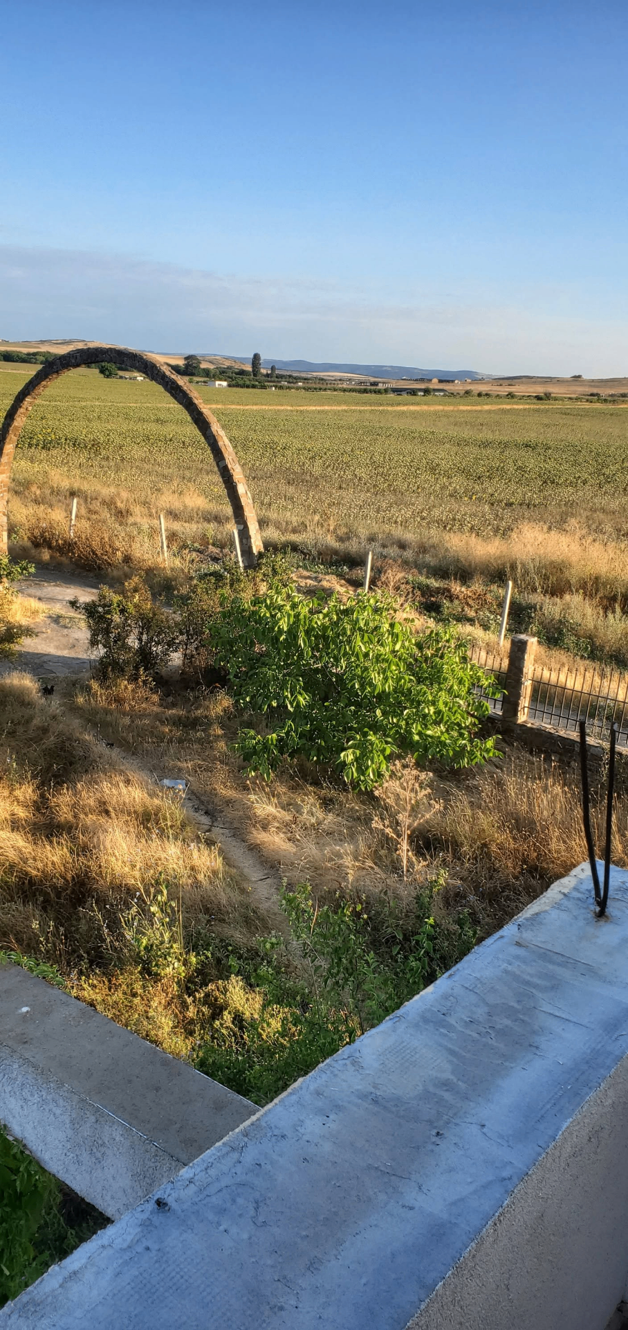 The stone arch at the entrance, opening to the fields