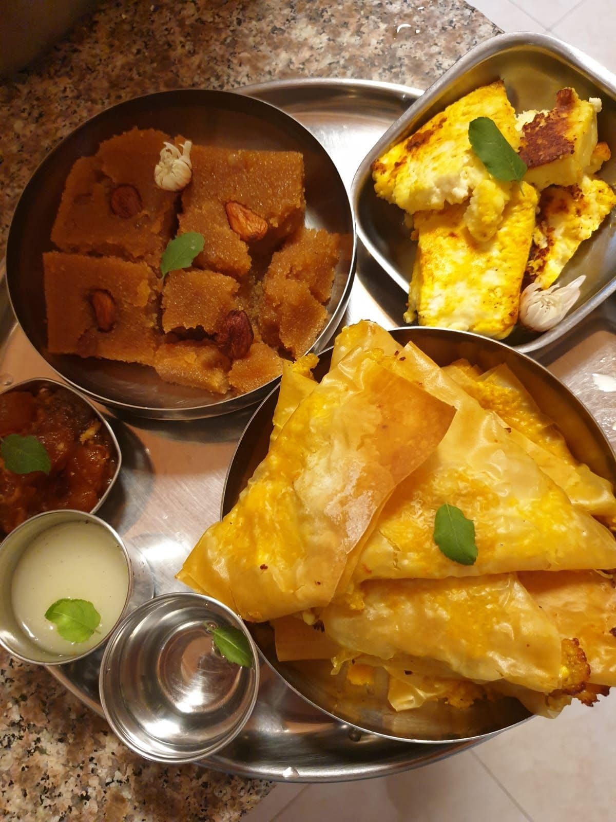 A prasādam plate — halavā, paneer and pastries offered to Krishna